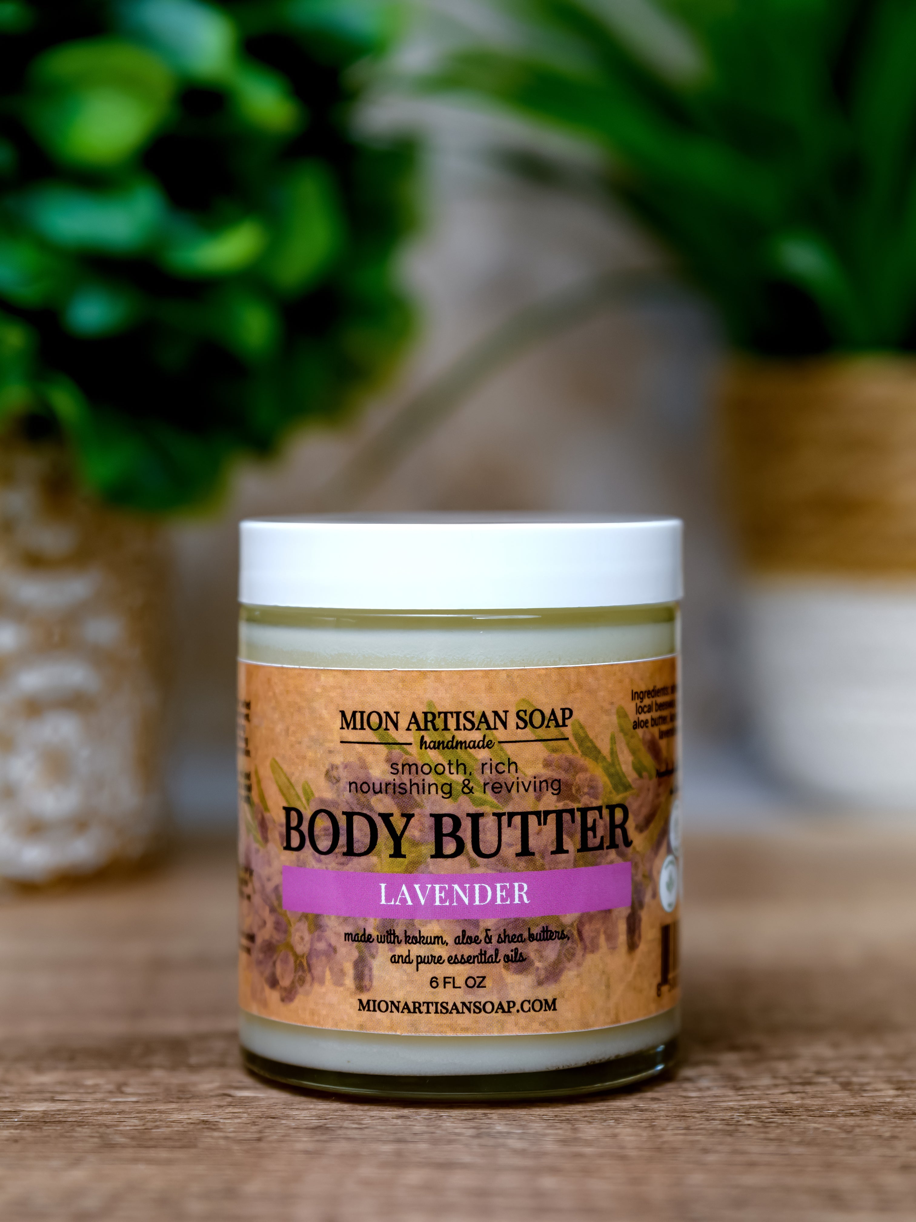 Jar of lavender body butter with a label on a wooden surface.