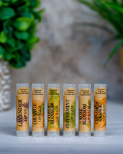 Set of lip balms with labels on a neutral background