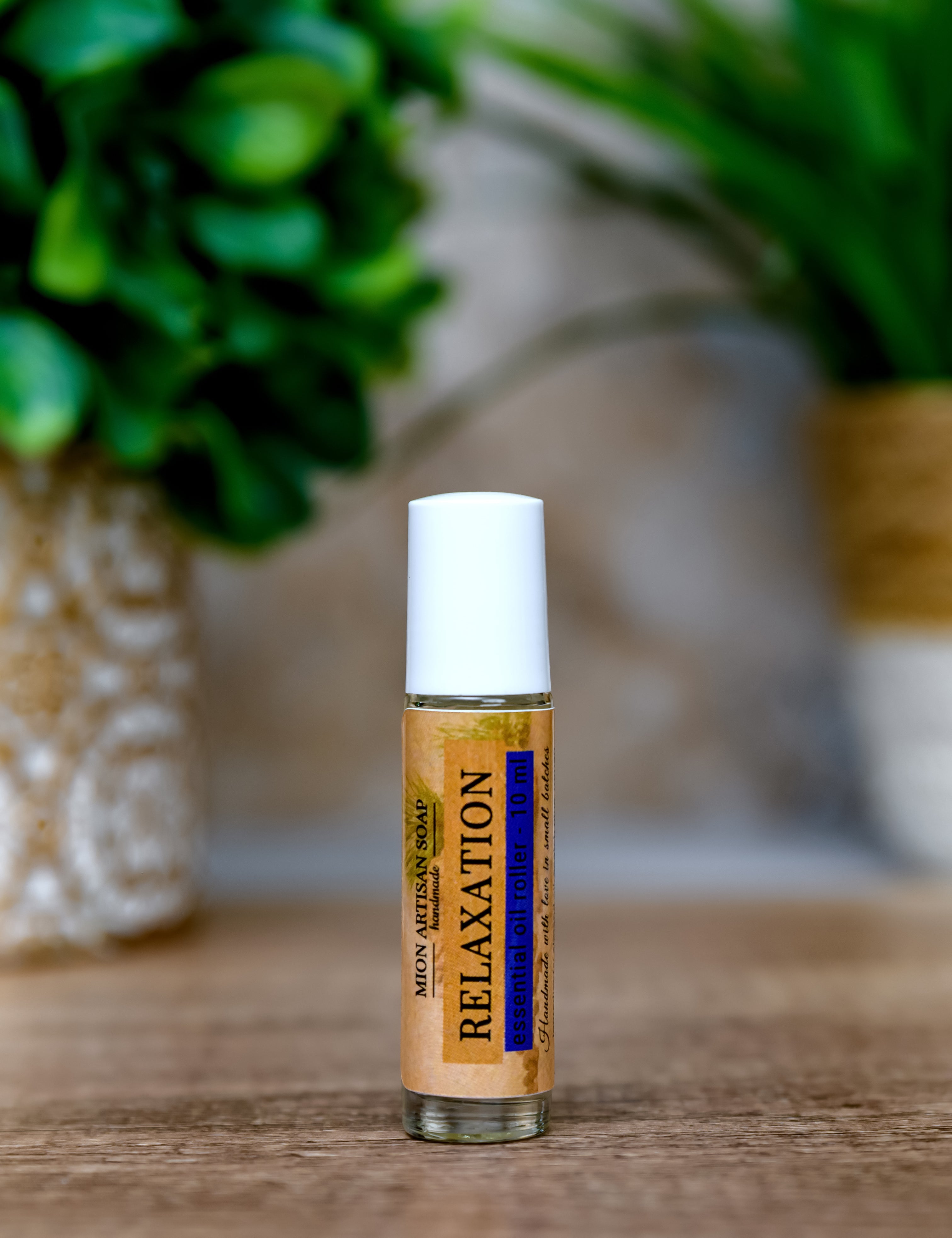 Roll-on bottle labeled 'Relaxation' on a wooden surface with greenery in the background