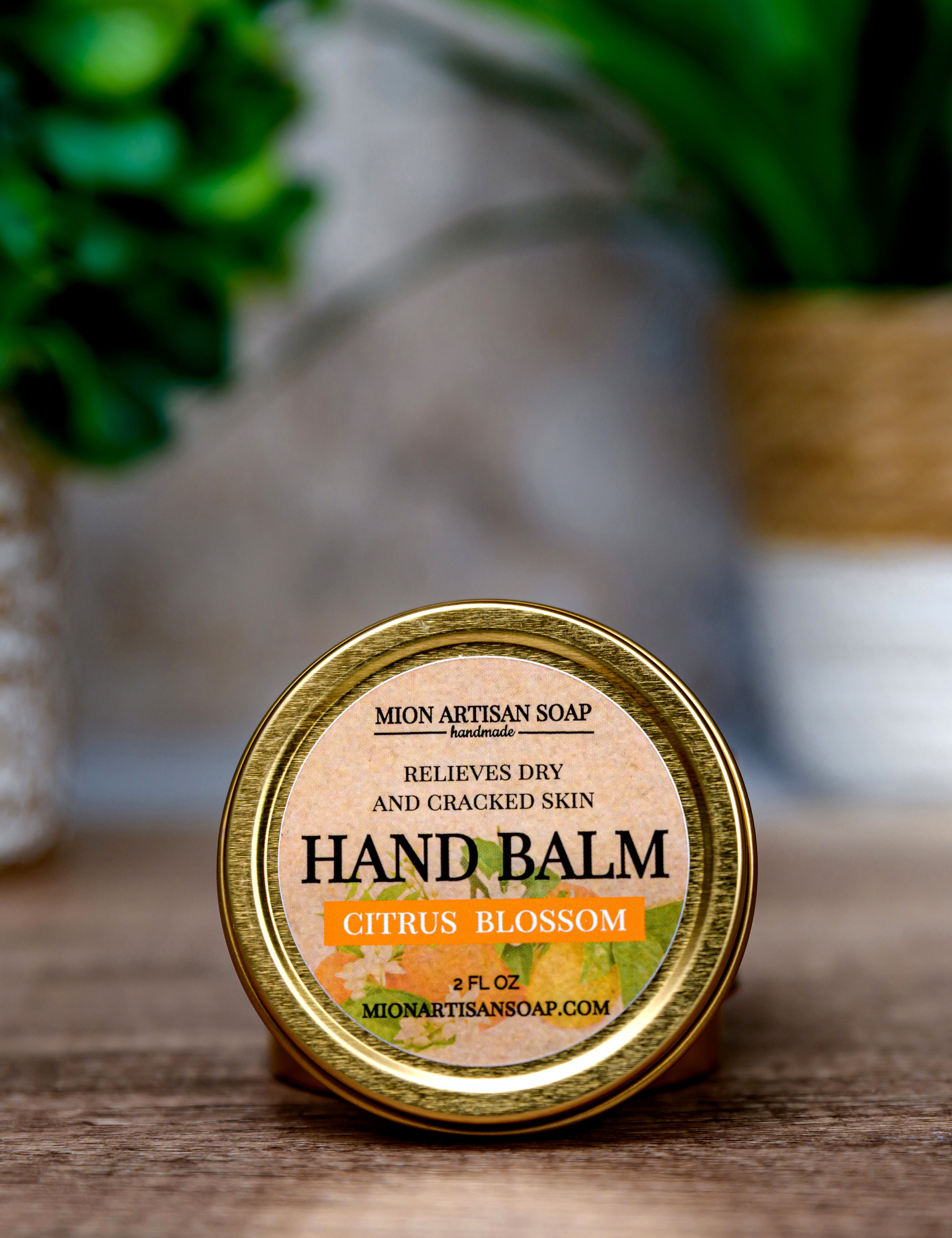 Hand balm container with 'Mion Artisan Soap' label on a wooden surface.
