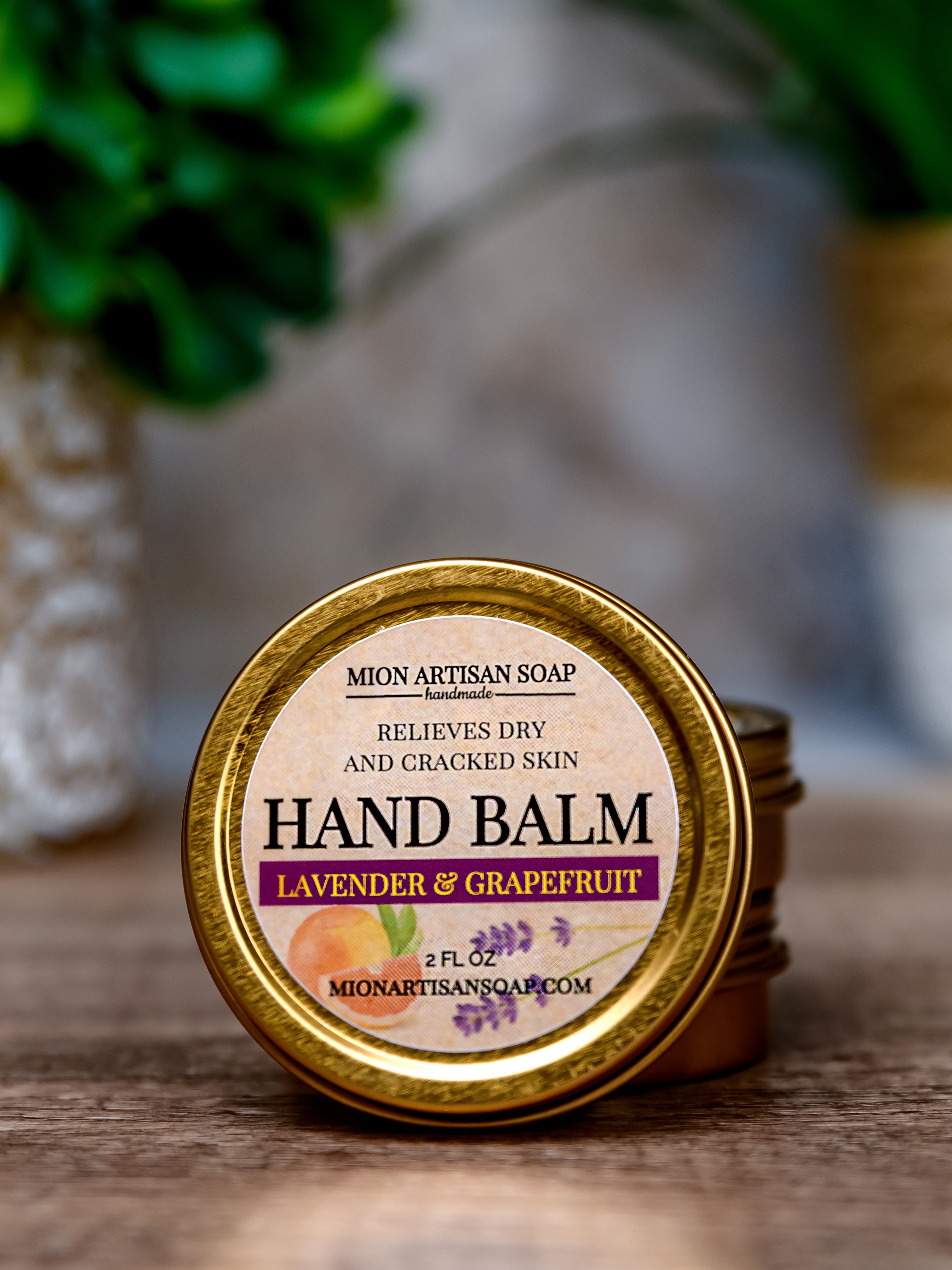 Hand balm container with lavender and grapefruit scent on a wooden surface