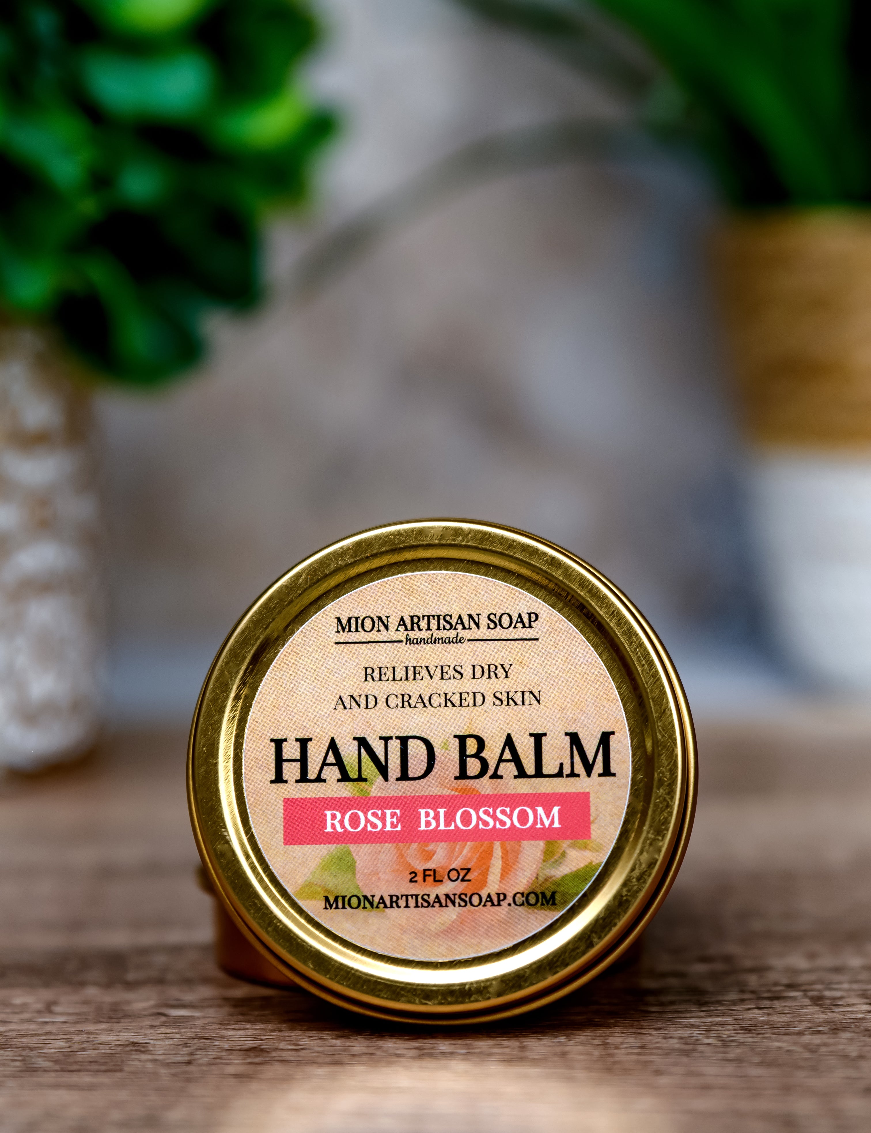 Hand balm container with 'Rose Blossom' label on a wooden surface