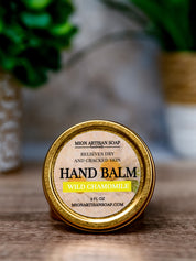 Hand balm container with 'Mion Artisan Soap' label on a wooden surface.
