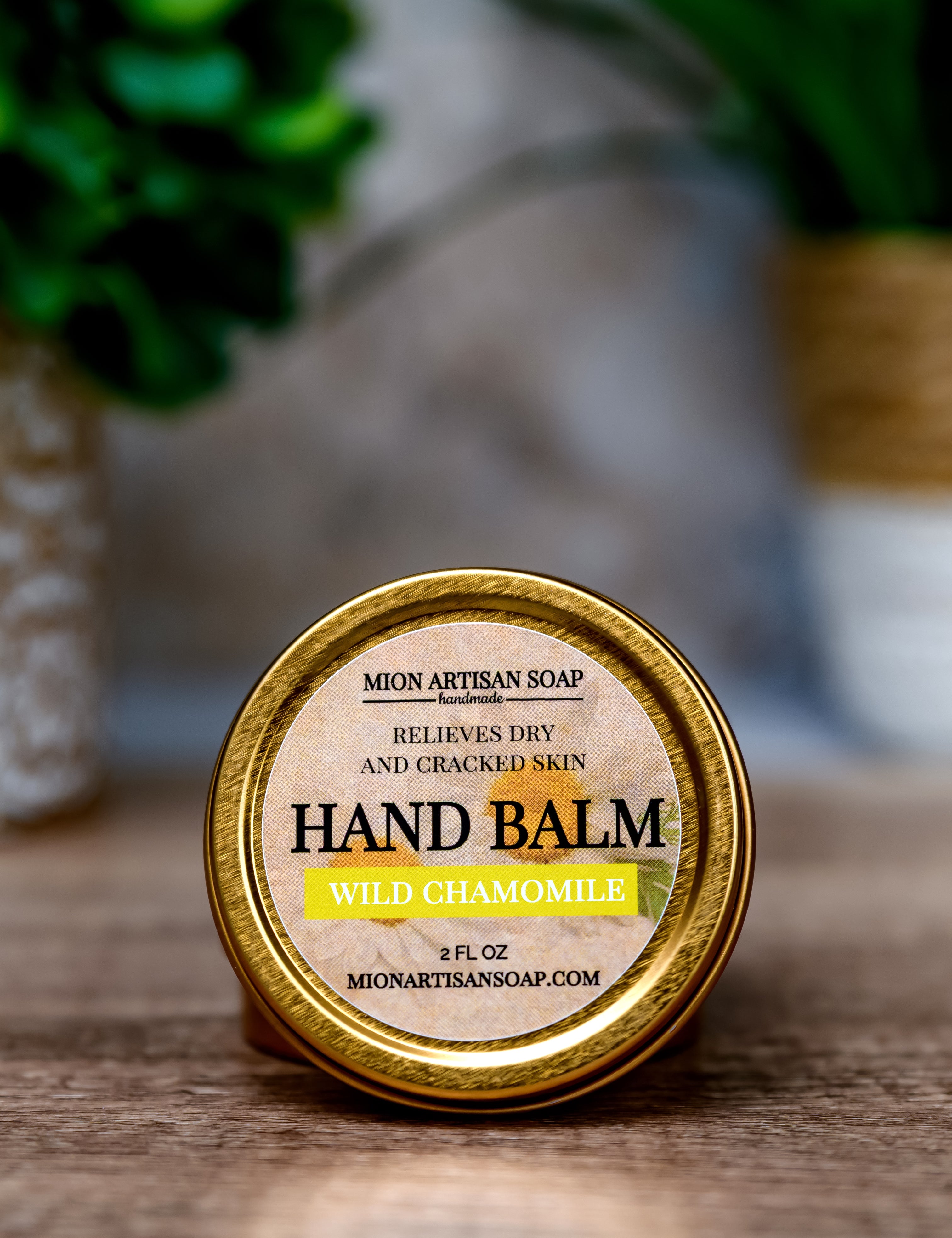 Hand balm container with 'Mion Artisan Soap' label on a wooden surface.