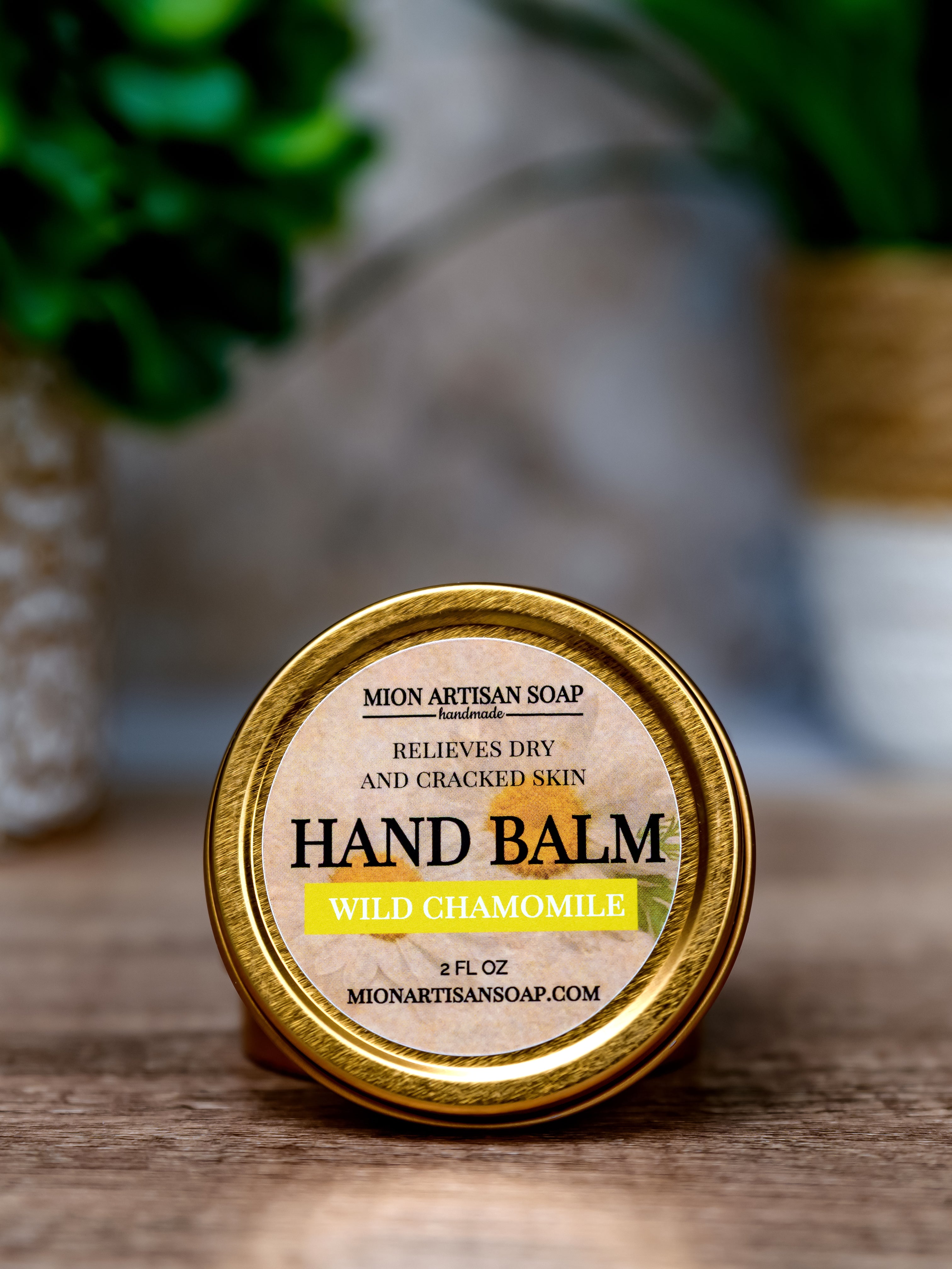 Hand balm container with 'Mion Artisan Soap' label on a wooden surface.